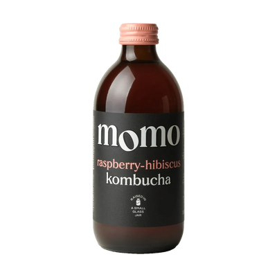 MOMO Raspberry & Hibiscus raw kombucha in an amber glass bottle with a pink cap and a black label with pink lettering.