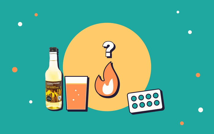 A glass and bottle of kombucha next to a flame with a question mark and a packet of antacids