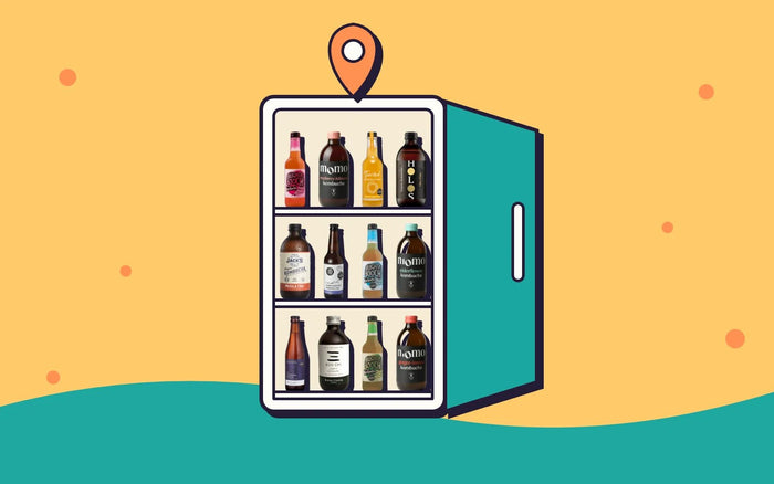 An open fridge full of kombucha with a map pin on top