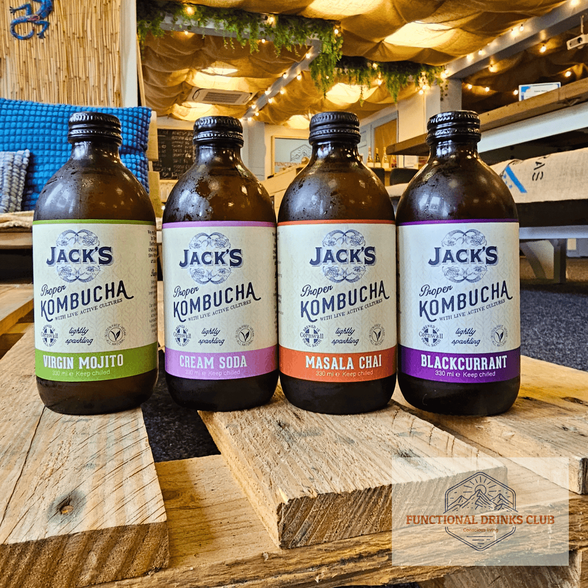 Four Jack's raw kombucha flavours, Virgin Mojito, Cream Soda, Masala Chai and Blackcurrant, lined up on a wooden pallet table in the Otley taproom.