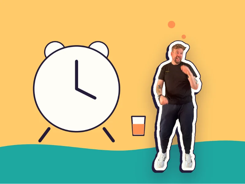 Week two: Kev beside a big alarm clock and his daily glass of kombucha