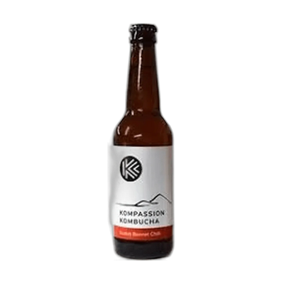 Kompassion Scotch Bonnet Chilli raw kombucha in a tall amber 330ml glass bottle with a black cap and a white label with a red flavour band.