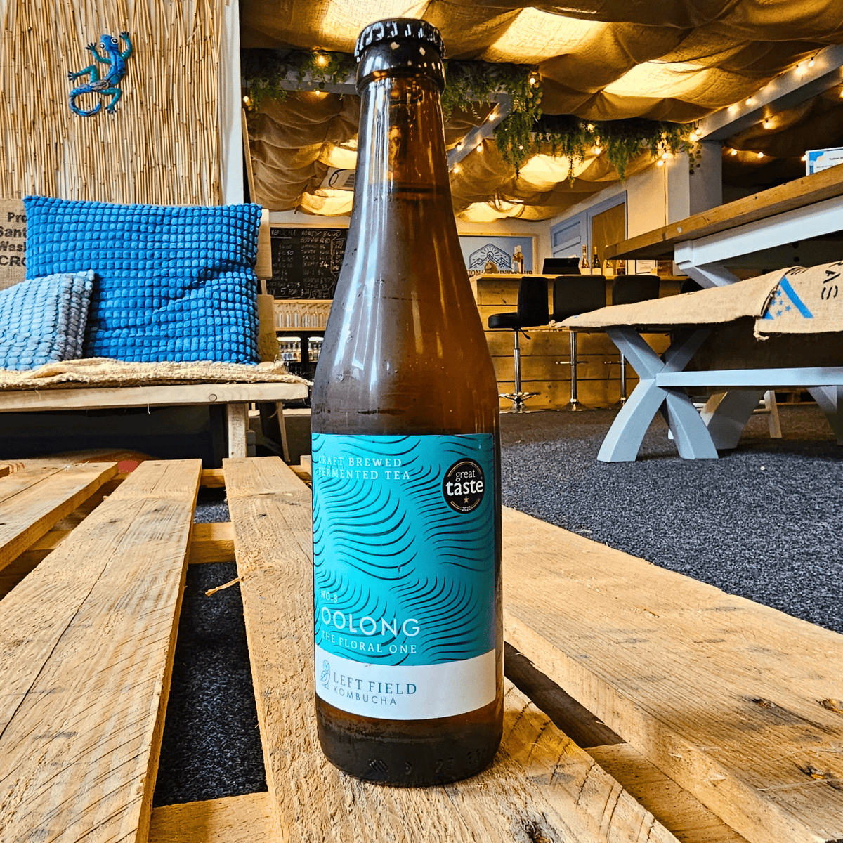 A bottle of Left Field No.3 Oolong raw kombucha on a wooden pallet table in the Otley taproom.