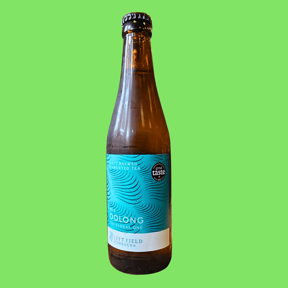 A bottle of Left Field No.3 Oolong raw kombucha on a lime green background.