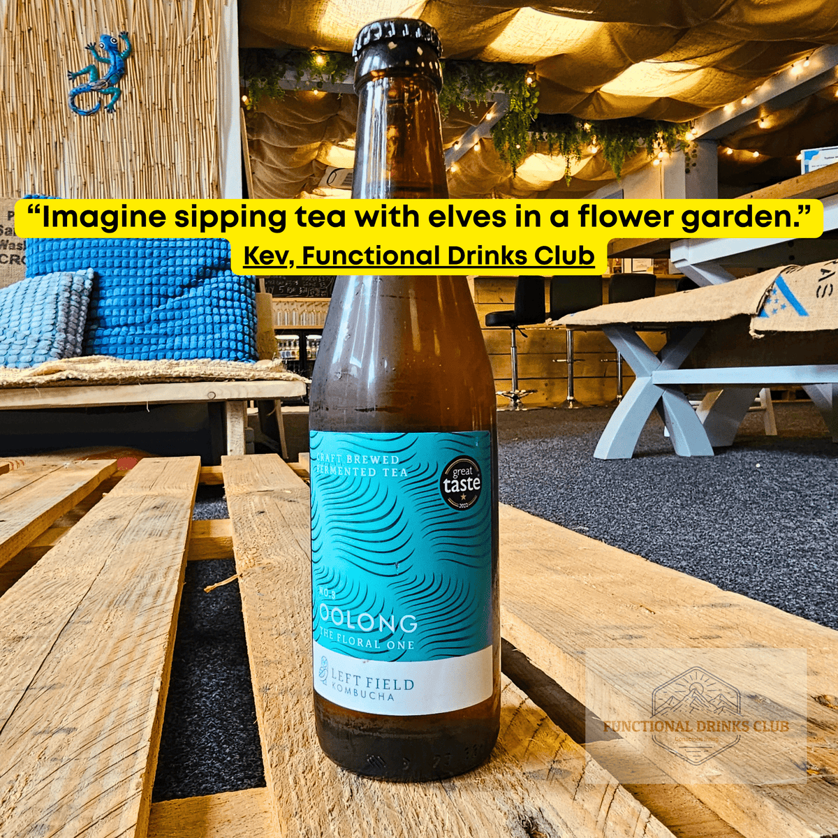 Left Field No.3 Oolong raw kombucha on a wooden pallet table in the Otley taproom, with Kev's tasting note: "Imagine sipping tea with elves in a flower garden."