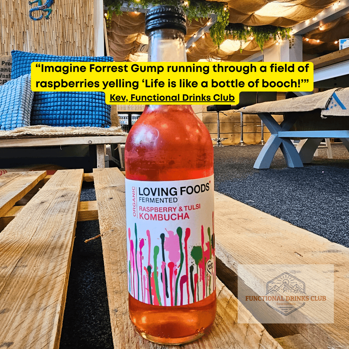 Loving Foods Raspberry & Tulsi raw kombucha on a wooden pallet table in the Otley taproom, with Kev's tasting note: "Imagine Forrest Gump running through a field of raspberries yelling 'Life is like a bottle of booch!'"
