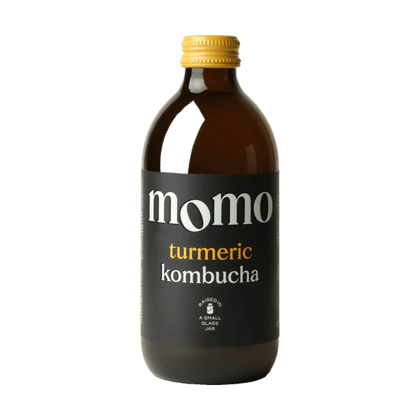 MOMO Turmeric raw kombucha in an amber glass bottle with a yellow cap and a black label with yellow lettering.