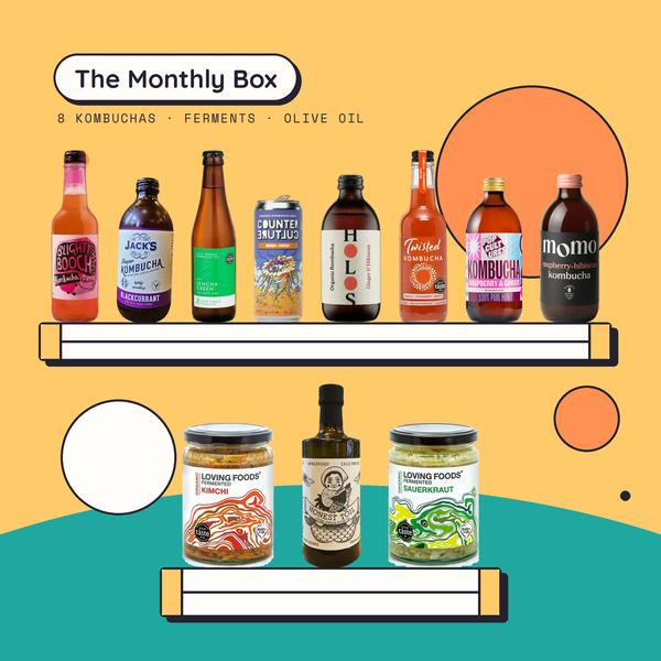 The Monthly Gut Health Box: eight kombuchas from eight different makers on the top shelf, with Loving Foods kimchi, Loving Foods sauerkraut and Honest Toil extra virgin olive oil below. Contents change every month.