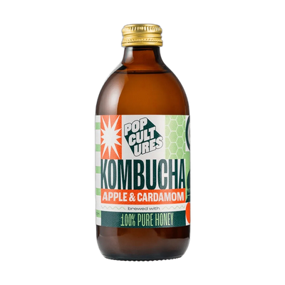 Pop Cultures Apple & Cardamom raw jun kombucha in an amber 330ml glass bottle with a gold cap and a colourful orange and green patchwork label.