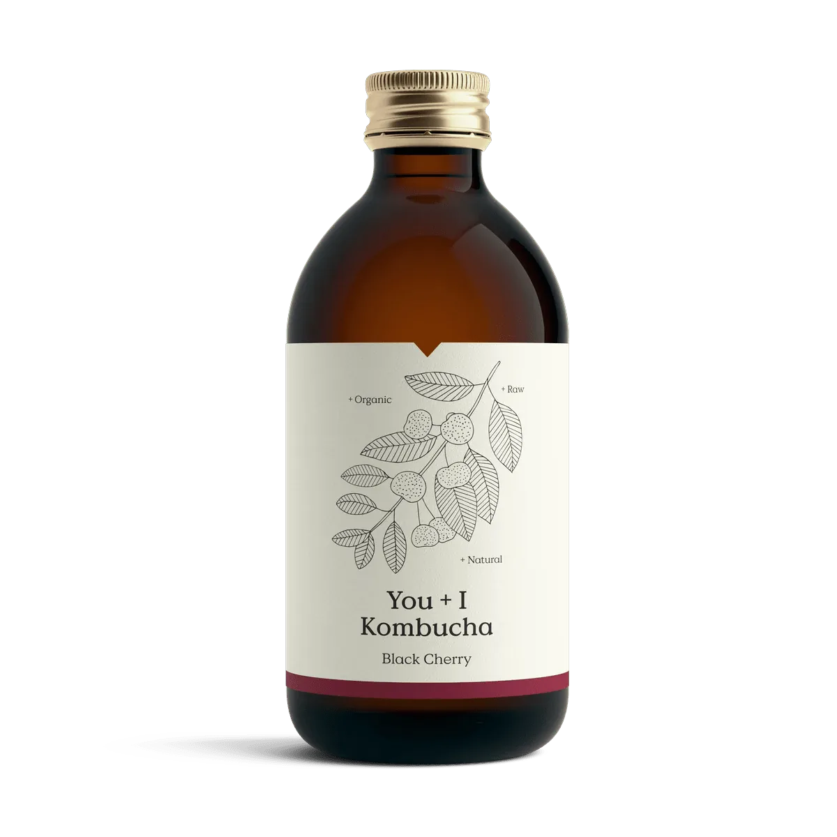 You + I Black Cherry raw kombucha in an amber glass bottle with a gold cap and a cream label with a botanical line drawing and a deep red band.