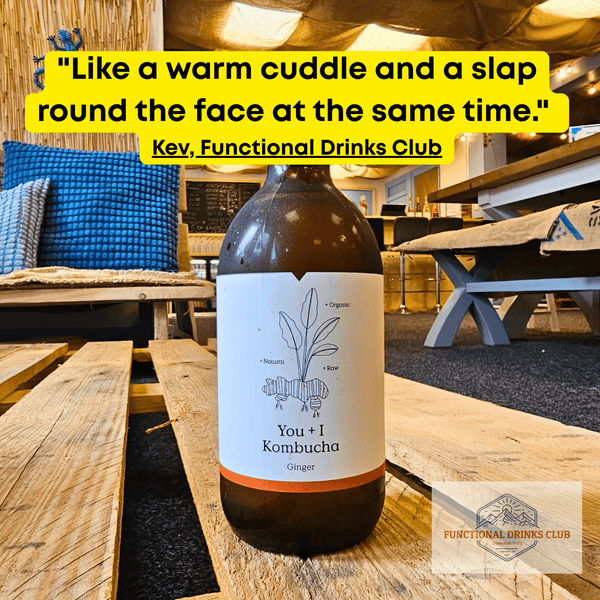 You + I Ginger raw kombucha on a wooden pallet table in the Otley taproom, with Kev's tasting note: "Like a warm cuddle and a slap round the face at the same time."