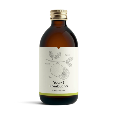 You + I Lime & Sea Salt raw kombucha in an amber glass bottle with a gold cap and a cream label with a botanical line drawing and a lime green band.